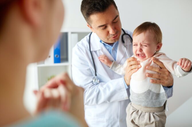 Doctor Or Pediatrician With Crying Baby At Clinic