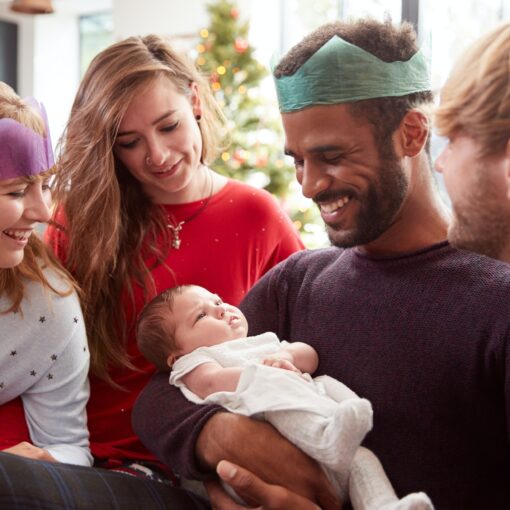 Gay Male Couple With Adopted Baby Daughter Celebrating First Christmas With Friends