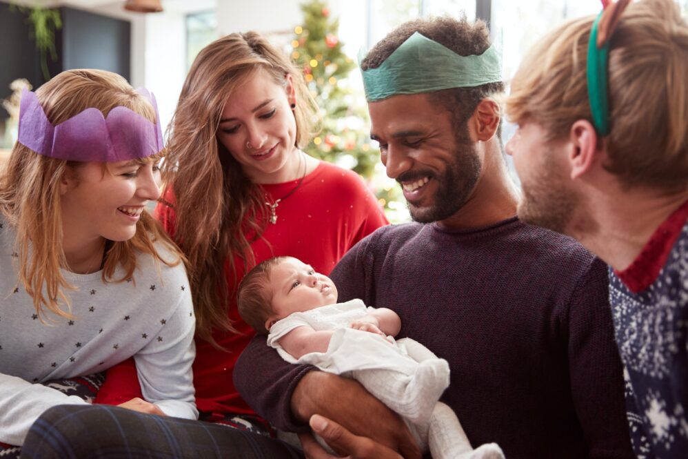 Gay Male Couple With Adopted Baby Daughter Celebrating First Christmas With Friends
