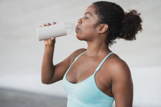 Fit African Girl Drinking Water After Sport Workout Outdoor