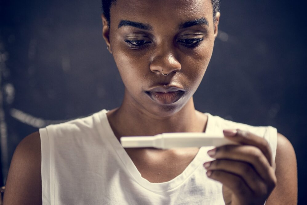 Closeup Of Black Woman With Pregnancy Test In A Hand